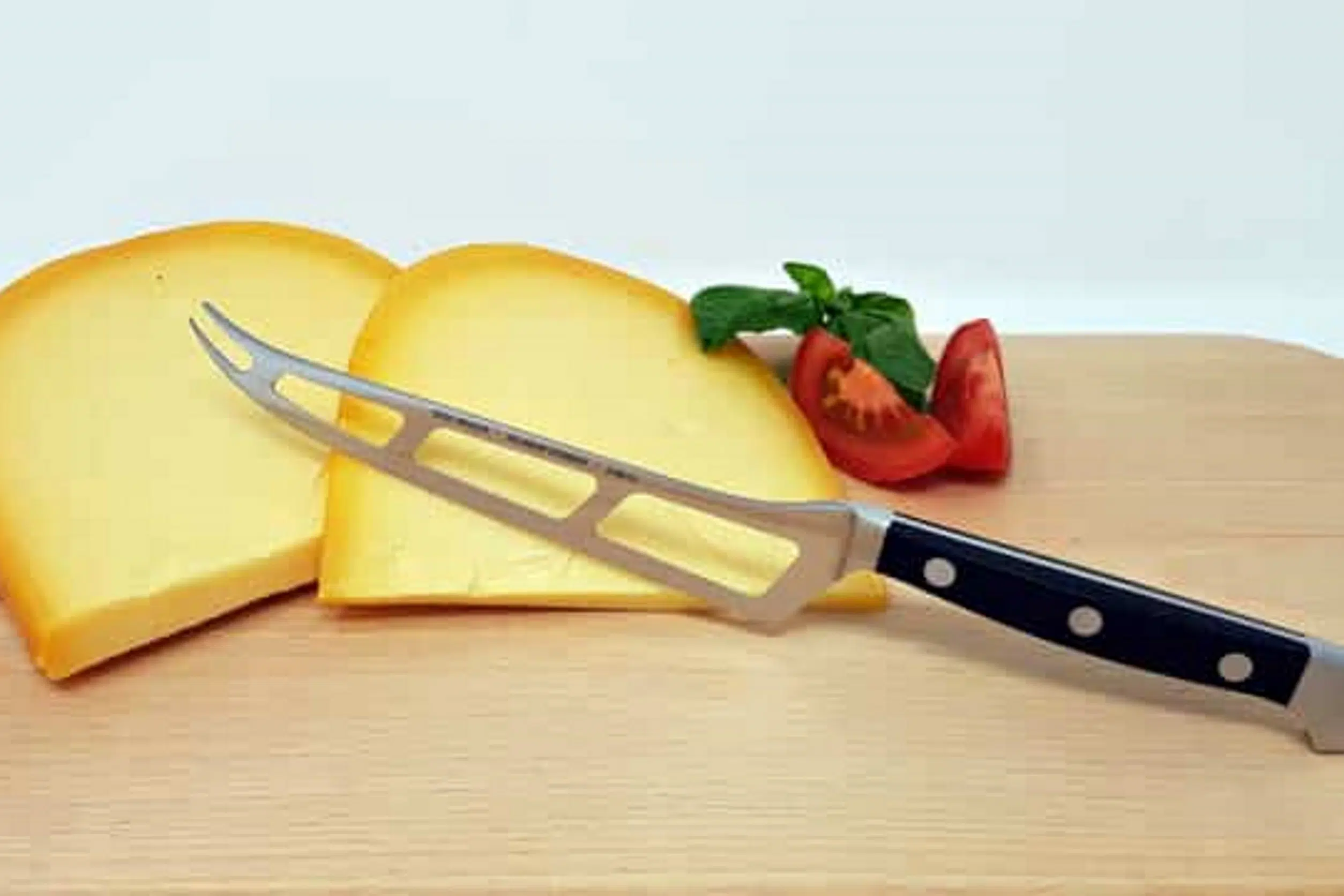 Käsemesser mit Käse auf Holzbrett